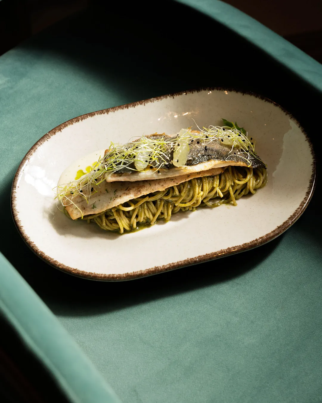 Sea bass fillet served with pesto spaghetti